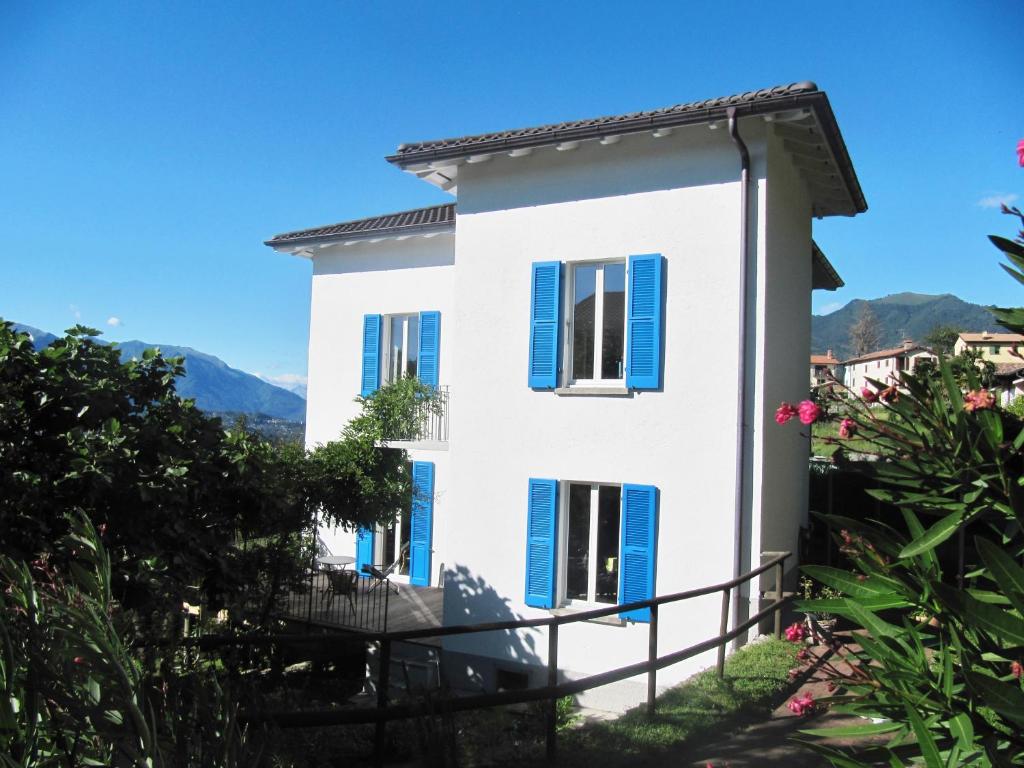 a white house with blue shutters on it at Ca' Dogana Vegia in Pugerna