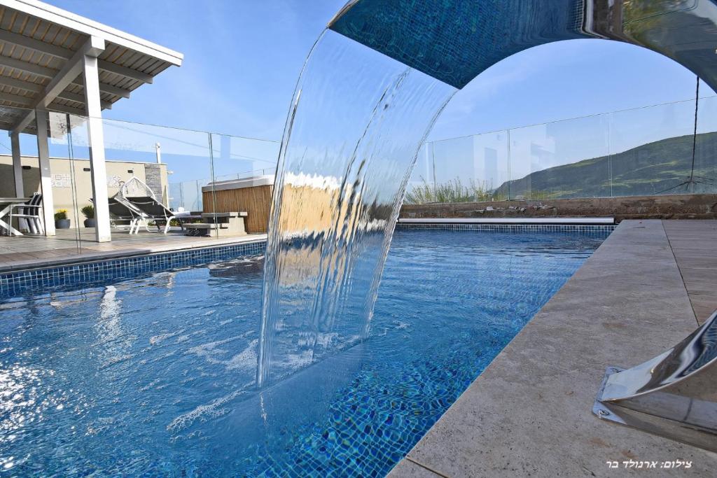 una fuente de agua en medio de una piscina en וילה מגדלא en Migdal