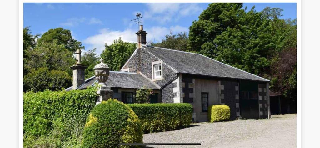 an old house with a cross on top of it at Cozy Cottage. Close to beach & woodland walks in Colinsburgh