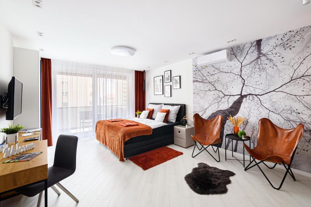 1 dormitorio con 1 cama, escritorio y sillas en TELEKI40 Apartman Győr CENTRAL, FREE PARKING, TERRACE, en Győr