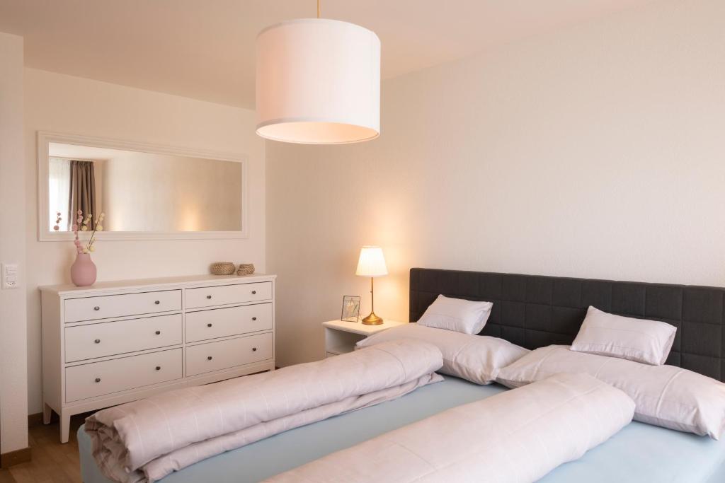 2 lits dans une chambre avec une commode et une chambre dans l'établissement Senevita Ahornpark, à Bätterkinden