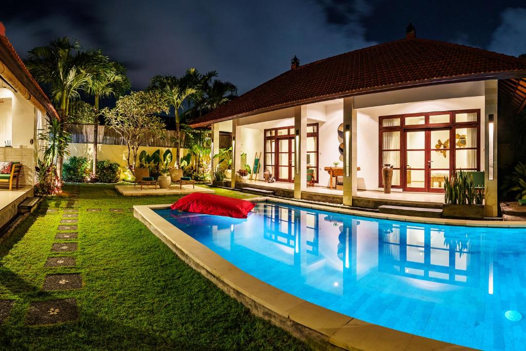 a swimming pool in front of a house at CASA BEGJA I Tranquil 2BR Villa w Private Pool in Mertanadi in Seminyak