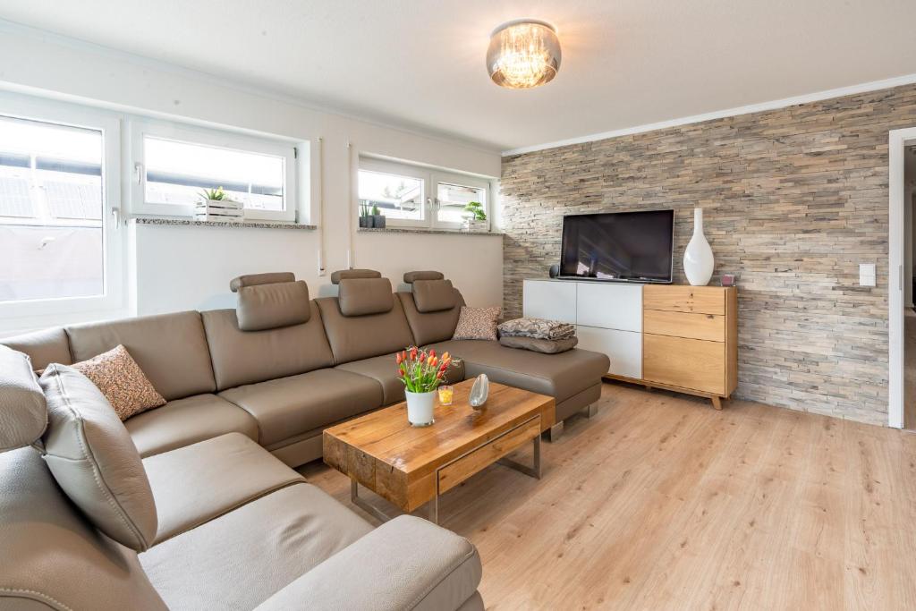 a living room with a couch and a tv at Alpenaster 2 in Sonthofen