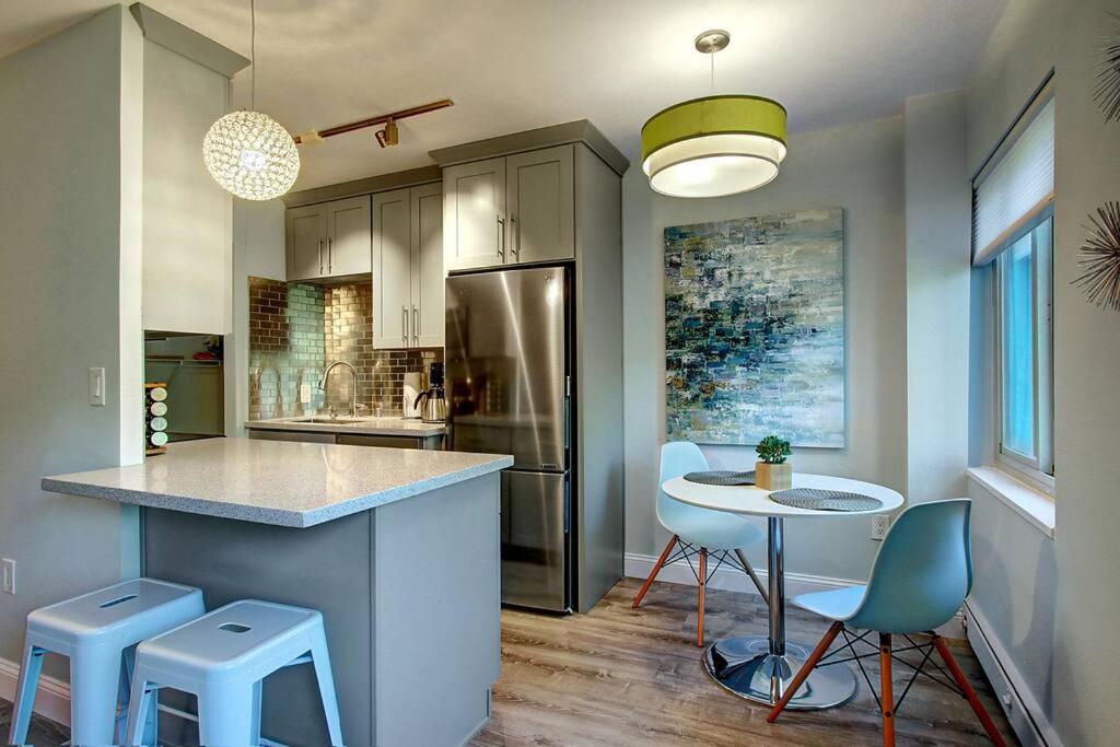 a kitchen with a counter and a table and chairs at Modern Coastal Downtown, King bed, Work Desk, Kitchen in Seattle