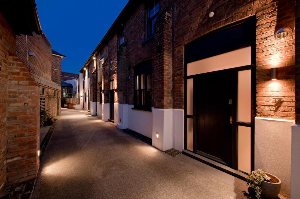 an empty alleyway with brick buildings and lights at My Unique Place - St Peters Mews in St. Albans