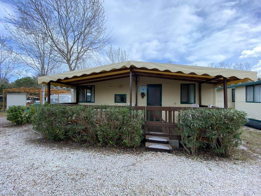 una casa con porche con techo en Comfortabele familie chalets met veranda incl airco dichtbij zee!, en Viareggio