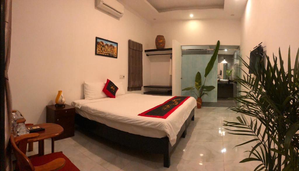 1 dormitorio con 1 cama en una habitación en Sunny Garden Homestay, en Hoi An