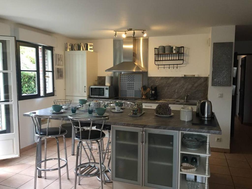 a kitchen with a large island with bar stools at Beautiful ground floor 2 bedroom apartment in Honfleur