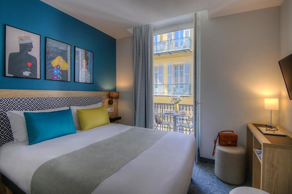 Cette chambre comprend un grand lit et une fenêtre. dans l'établissement Bristol Nice, à Nice