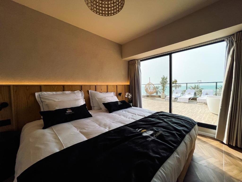 a bedroom with a large bed with a large window at Share Suites Hotel Bat-Yam in Bat Yam