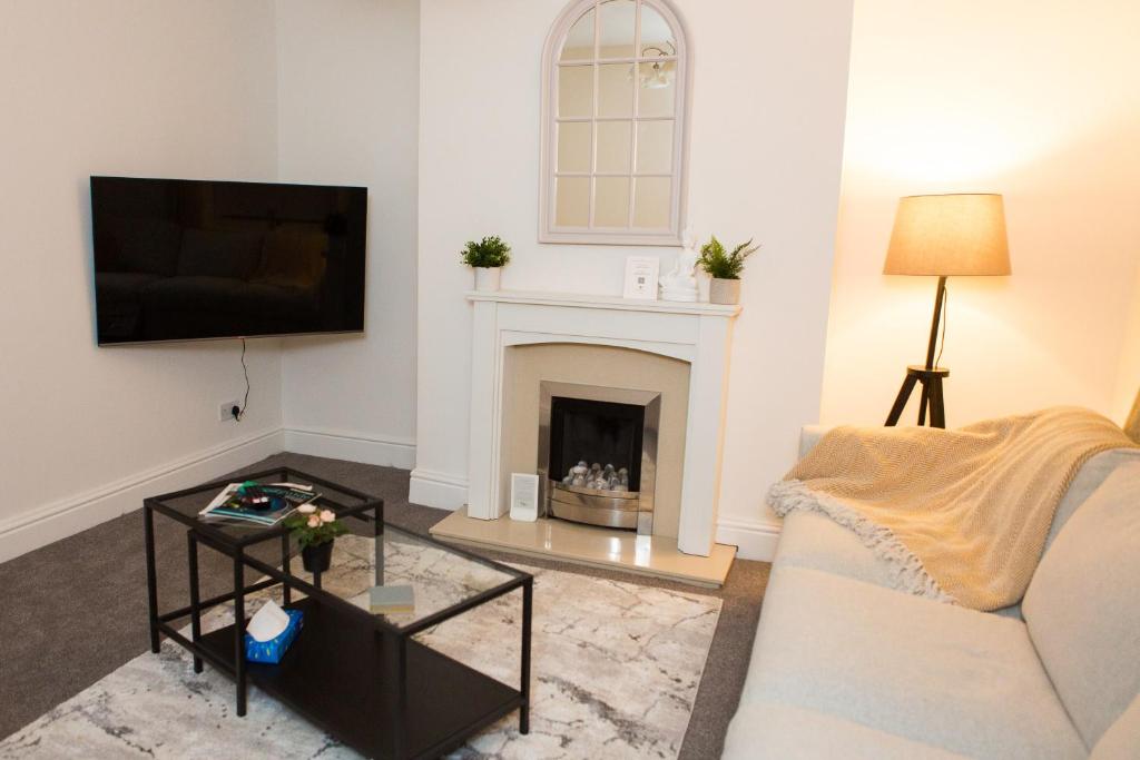 a living room with a couch and a fireplace at High Peak Place - Spacious Whaley Bridge Townhouse in Whaley Bridge