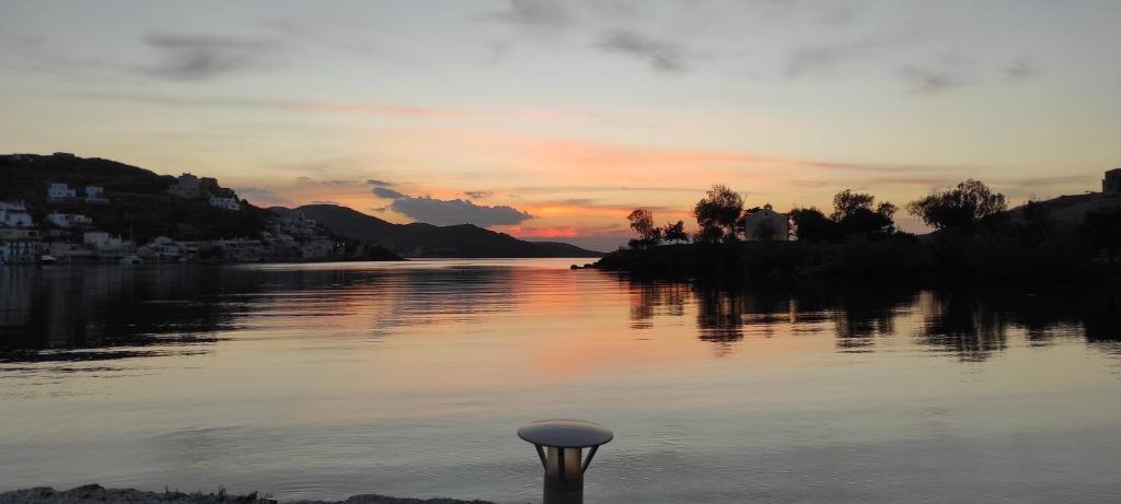 eine Stange im Wasser mit Sonnenuntergang im Hintergrund in der Unterkunft Amazing 2 bedroom apartment overlooking the Marina of Vourkari in Ioulis