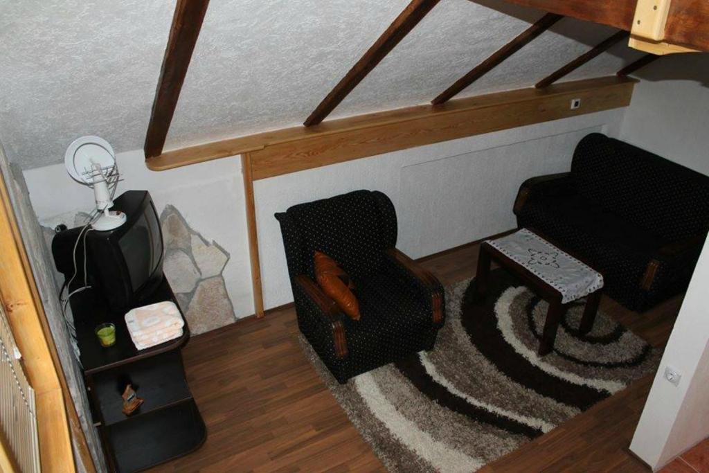 uma sala de estar com uma cadeira e uma televisão em Apartments Vojinovic em Žabljak