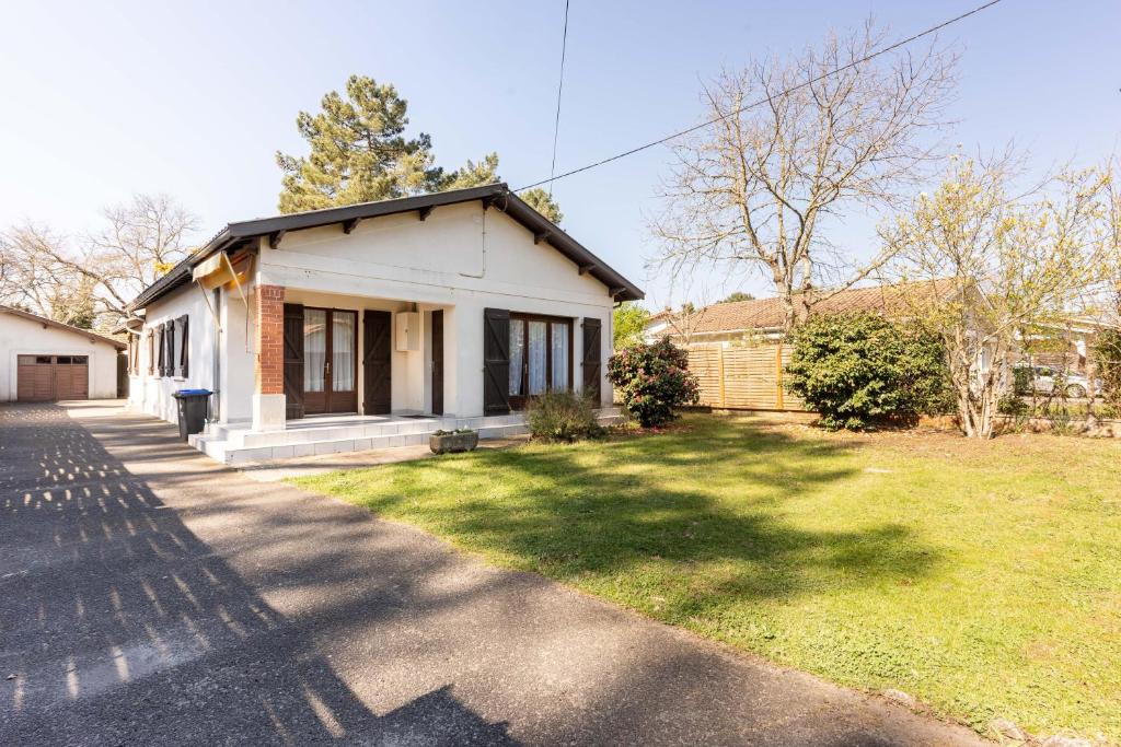 a small white house with a grass yard at Odessa in Lanton