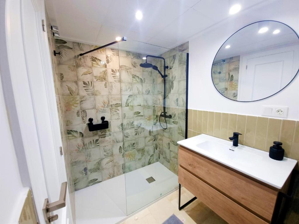 uma casa de banho com um chuveiro, um lavatório e um espelho. em Charlot Center Apartment I em Alicante