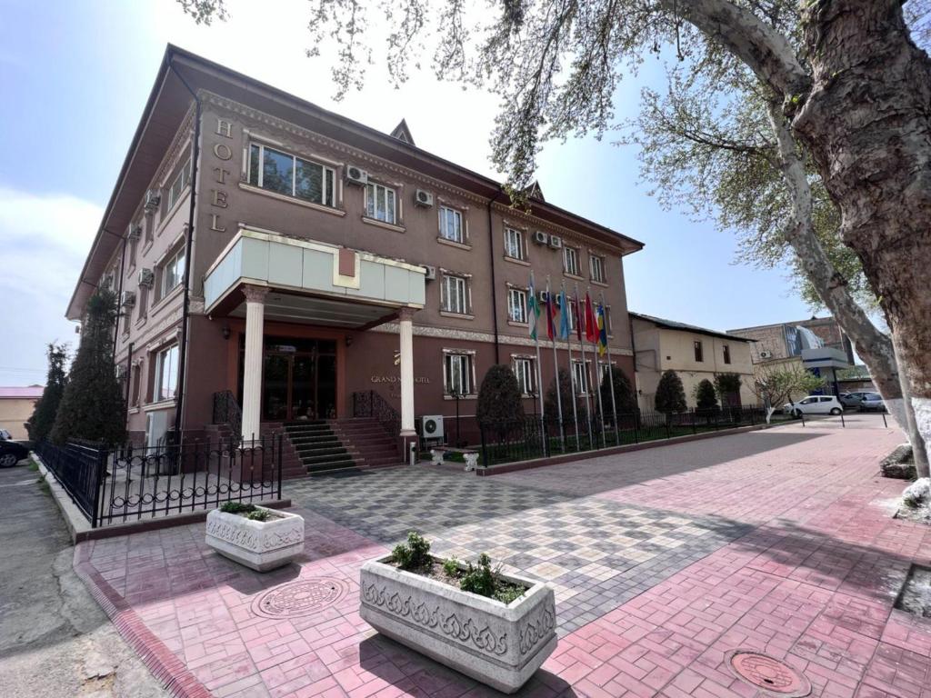 un edificio en una calle con dos plantas delante en Grand Nur Hotel, en Tashkent
