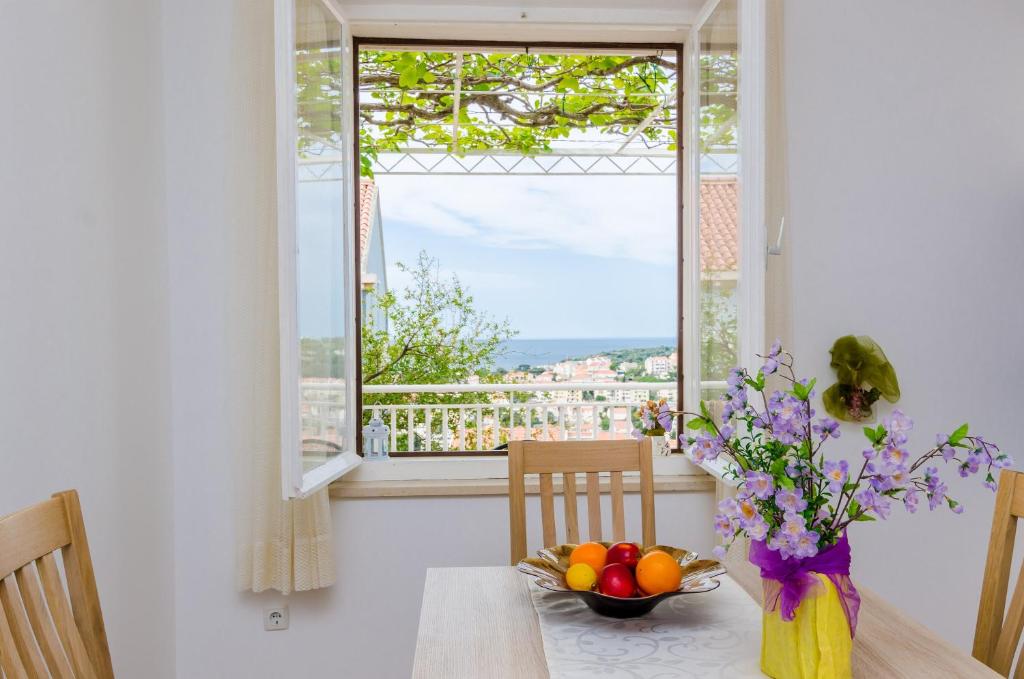 a dining room table with a bowl of fruit and a window at Rooms Rita in Dubrovnik
