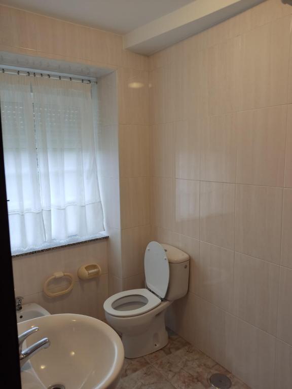 a bathroom with a toilet and a sink at OS MUIÑOS in Ribadeo