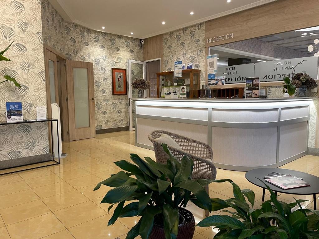 a store lobby with a counter and chairs and plants at San Luis in Vilaboa