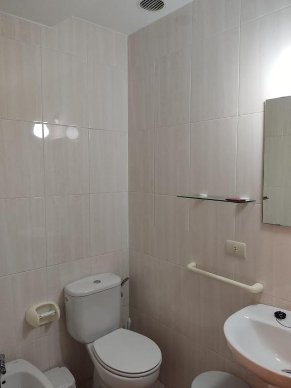 a white bathroom with a toilet and a sink at OS MUIÑOS in Ribadeo
