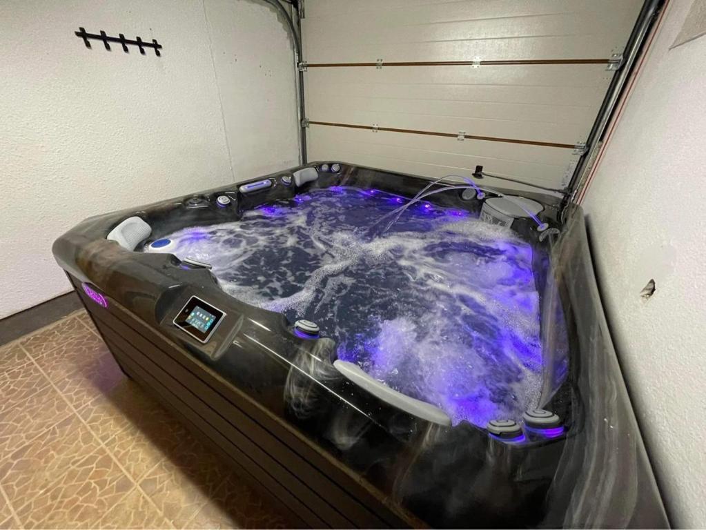 eine Whirlpool-Badewanne mit blauen Lichtern in einem Zimmer in der Unterkunft Fenyves Sor Apartman in Orfű