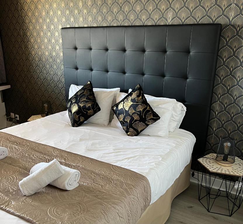 a bedroom with a large bed with a black headboard at Resothel Group in Le Cannet