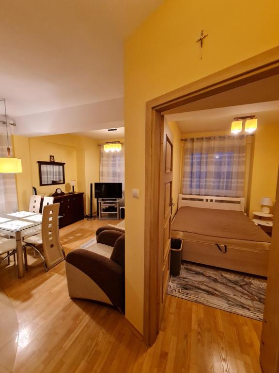 Apartament w Centrum في بلوك: غرفة نوم مع سرير وغرفة معيشة