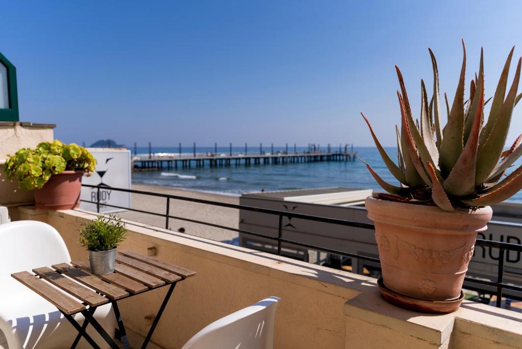 una mesa y sillas en un balcón con vistas al océano en Appartamento fronte mare con terrazzo zio, en Alassio