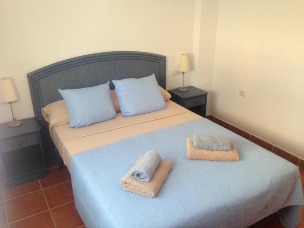 1 dormitorio con 1 cama con toallas en AZ02 Roof top terrace apartment, 2 bedrooms, 1 bathroom, very close to beach, en La Azohía