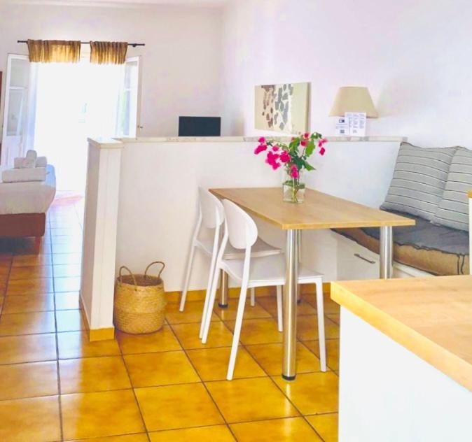 uma cozinha e sala de estar com mesa e cadeiras em Romanos apartments em Gaios