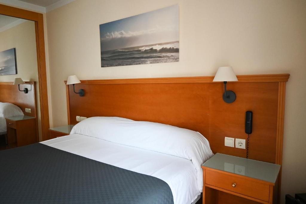 1 dormitorio con 1 cama con cabecero de madera en Hotel Doña Catalina, en Marbella