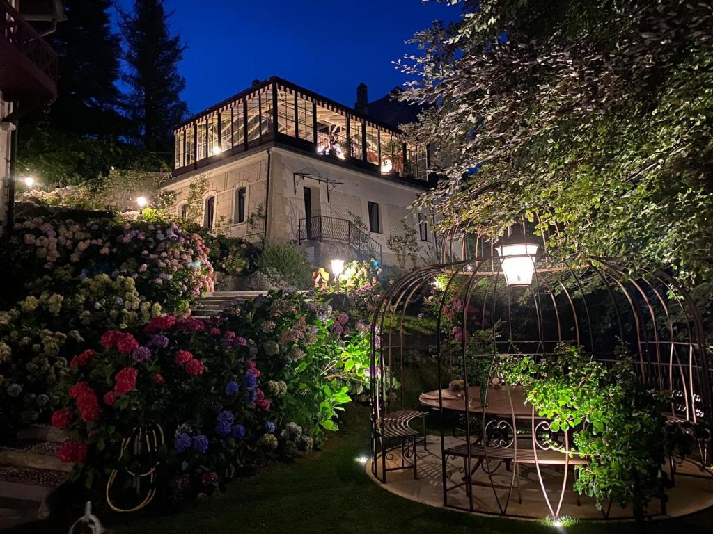 un giardino con tavoli e fiori di notte di Relais Villino Rubini a Brunate