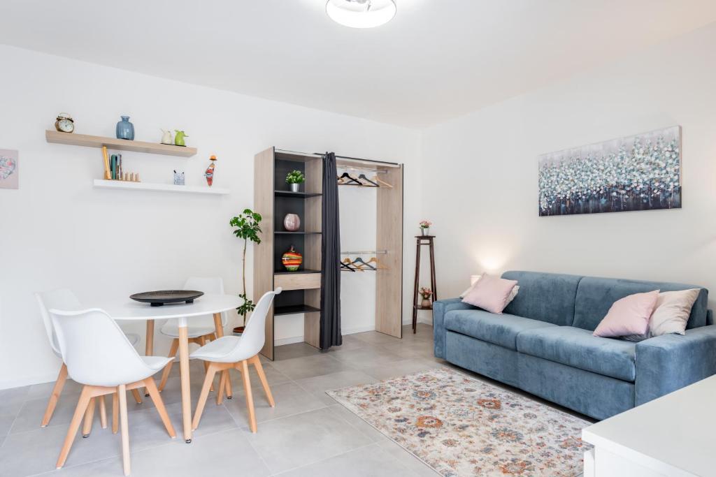 a living room with a blue couch and a table at Casa Alchisi - Teatro Romano Cozy Apartment in Catania