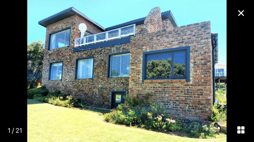 a brick house with a balcony on top of it at Boggoms' View in Boggomsbaai
