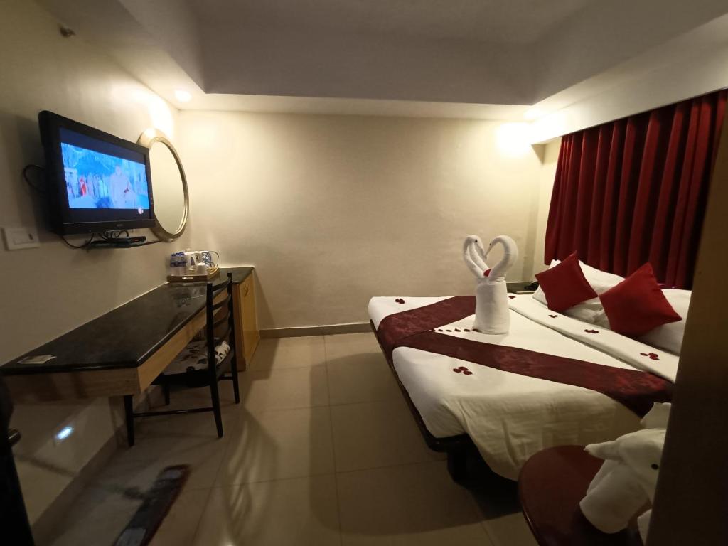 a hotel room with two beds and a television at Savera Hotel in Chennai