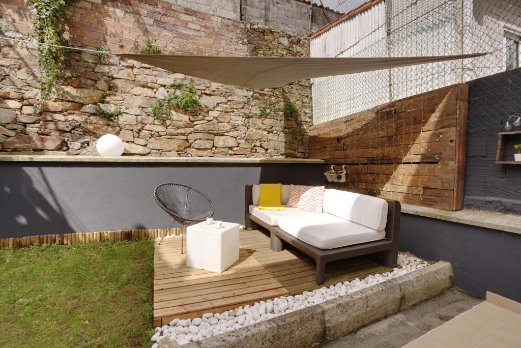 um pátio com um sofá e uma mesa num edifício em VM Apartamentos Turísticos em Santiago de Compostela
