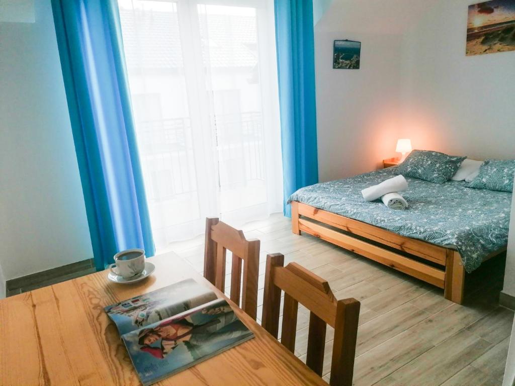um quarto com uma cama e uma mesa e uma mesa sidx sidx sidx em Willa Artus em Władysławowo