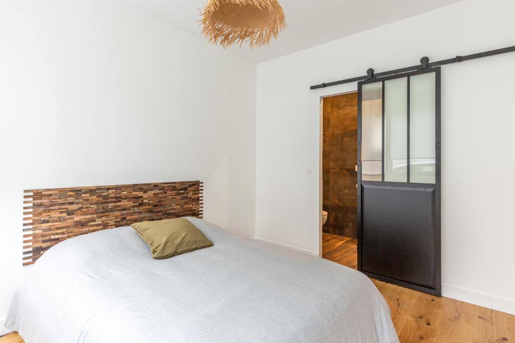 a bedroom with a white bed and a brick wall at Suite in Suresnes