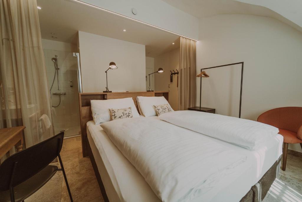 a bedroom with a large white bed and a desk at Burghotel Schlaining in Stadtschlaining