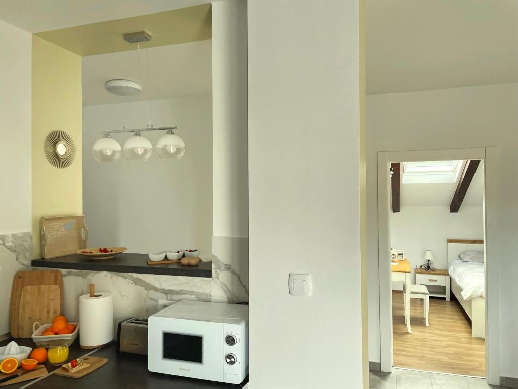 kuchnia z kuchenką mikrofalową oraz pokój z łóżkiem w obiekcie Harbor apartments 2 w mieście Opatija