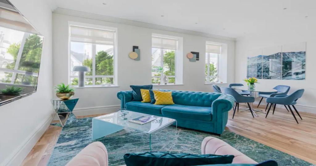 a living room with a blue couch and a table at OFF Covent Garden SUPERB SPACIOUS BRIGHT LUXXE DESIGN HOME- YOUR WISH GRANTED! in London