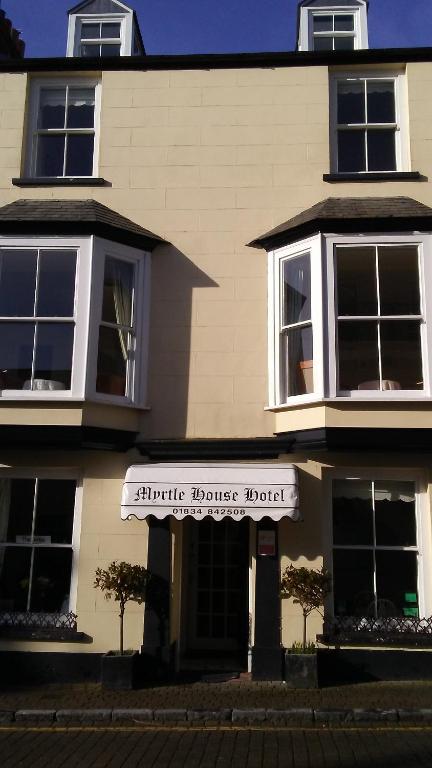 MYRTLE HOUSE HOTEL TENBY في تينبي: مبنى عليه لافته مكتوب عليها فندق هانتر هاوس