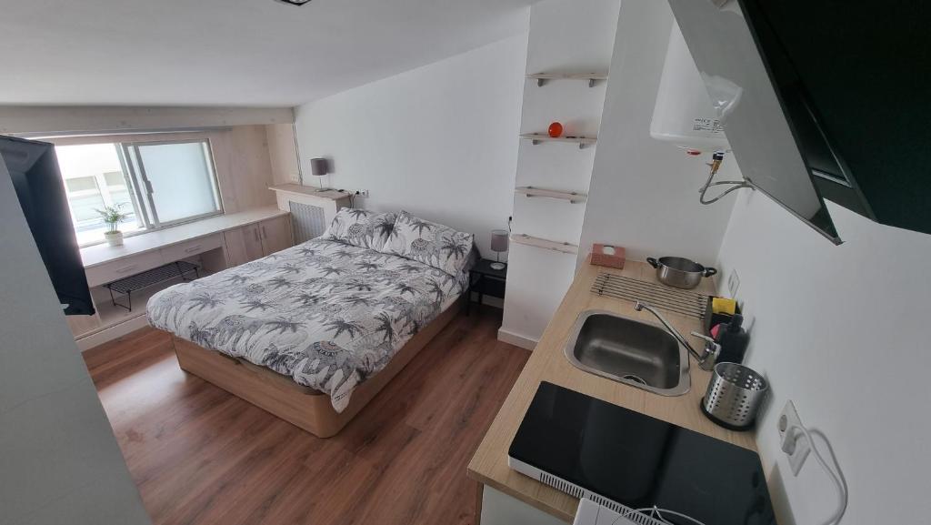 a small bedroom with a bed and a desk at Estudio Acogedor en el Centro in Santiago de Compostela