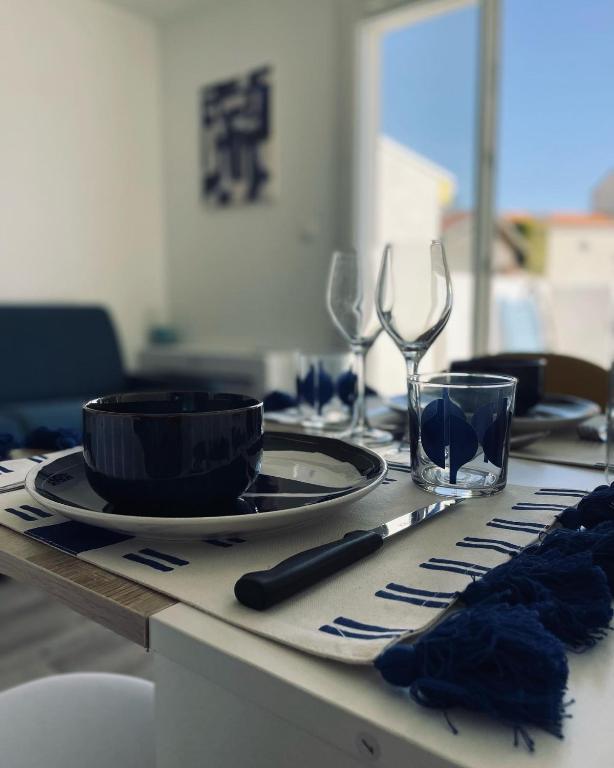 una mesa con un plato y copas de vino. en Logis des pêcheurs en Meschers-sur-Gironde