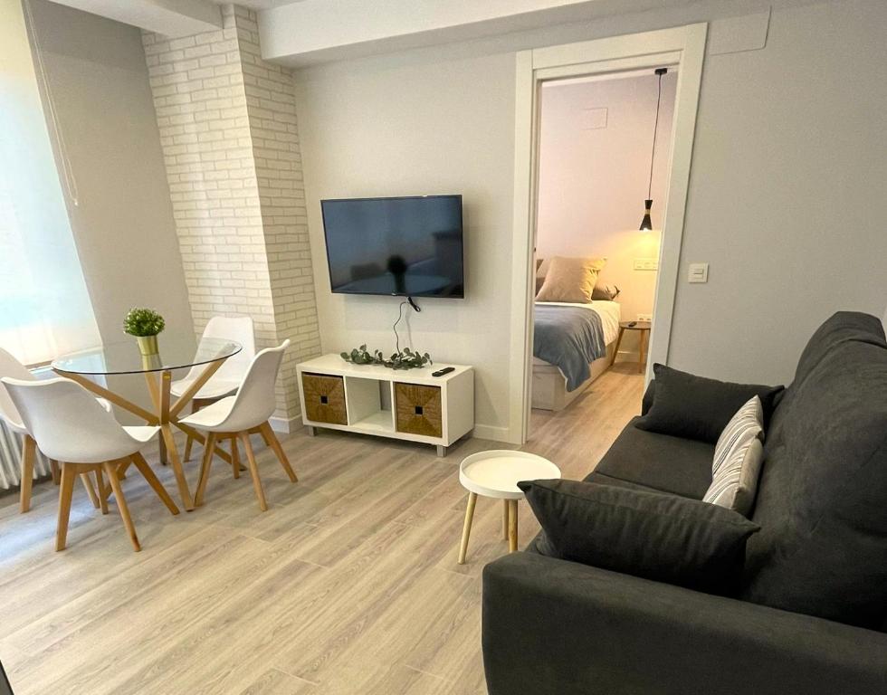 - un salon avec un canapé et une table dans l'établissement Apartamentos Aranda - VUT- La Cepa I - II, à Aranda de Duero