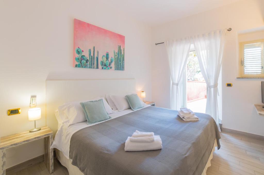 a bedroom with a large bed with two towels on it at Hotel Villino Gallodoro in Taormina