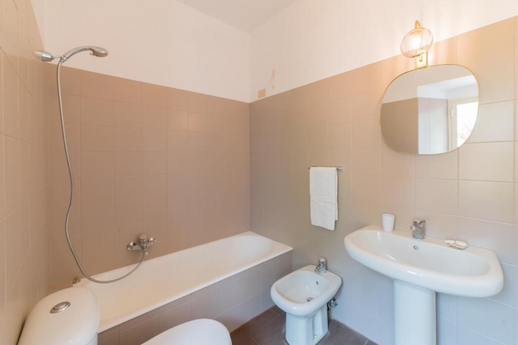 a bathroom with a sink and a toilet and a tub at Hotel Villino Gallodoro in Taormina