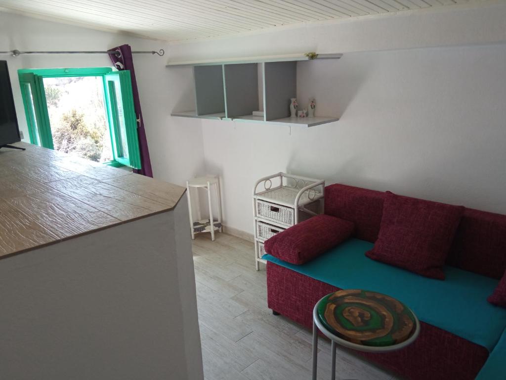 a living room with a red couch and a kitchen at KATY&MLADEN in Baška