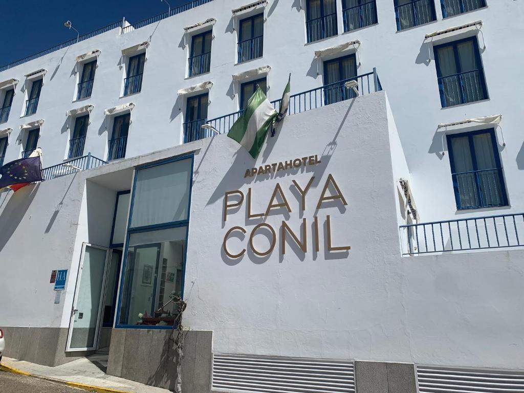 un edificio blanco con un cartel de control de playa en él en Apartahotel Playa Conil, en Conil de la Frontera