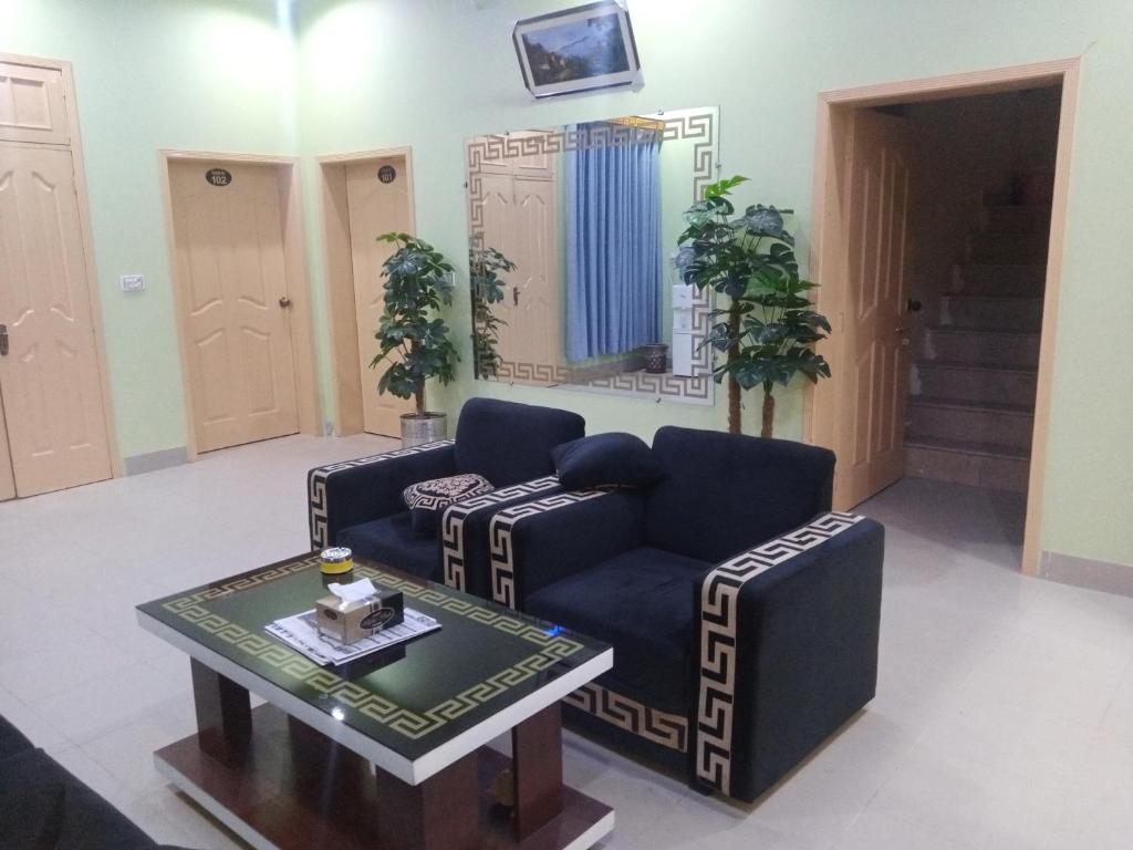 een woonkamer met een bank en een tafel bij Hotel Royal Star in Multan